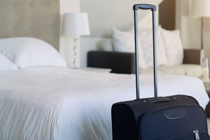 Travel, hotel and luggage, a room on vacation to relax or business trip for international work. Tourism, hospitality and bed and breakfast, luxury holiday from work. A bedroom and suitcase for summer